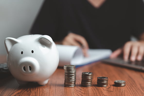 An image of a businessman holding a piggy bank, representing the need for small business loans to survive the recession. Alt text: businessman holding a piggy bank.