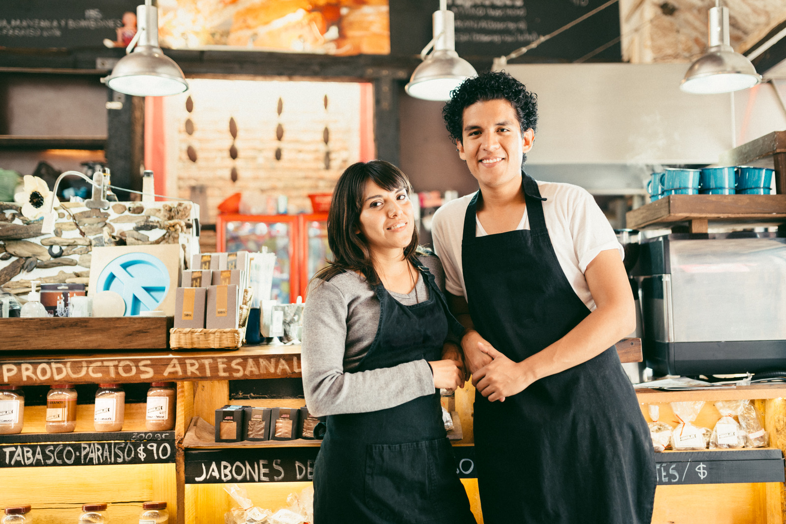 Small Business Owners standing by the counter of his Chocolate and Coffee speciality business.